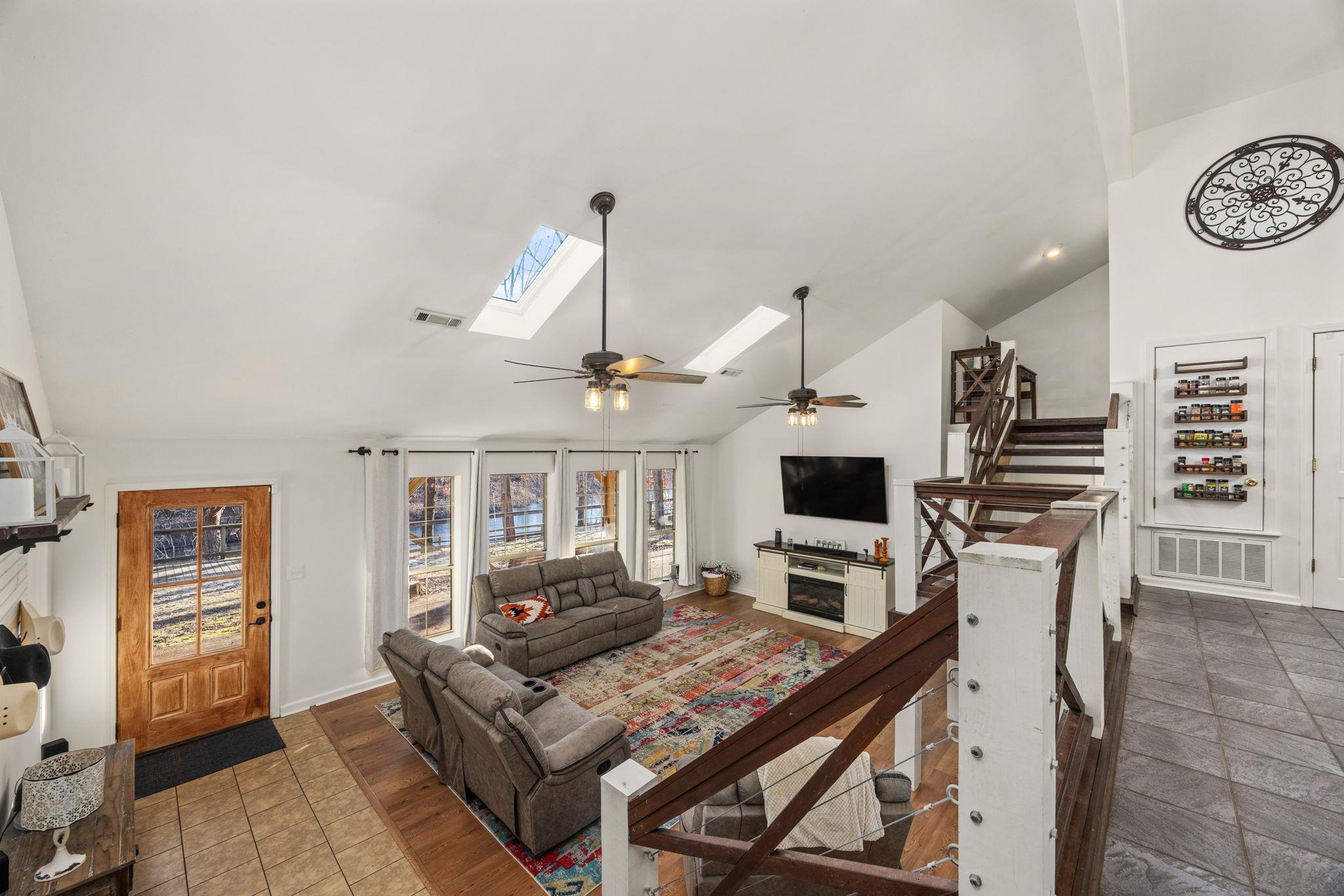113 Horseshoe Lake Road Saltillo, MS 38866 - Photo 13 of 39 Living room featuring ceiling fan, high vaulted ceiling, and a skylight
