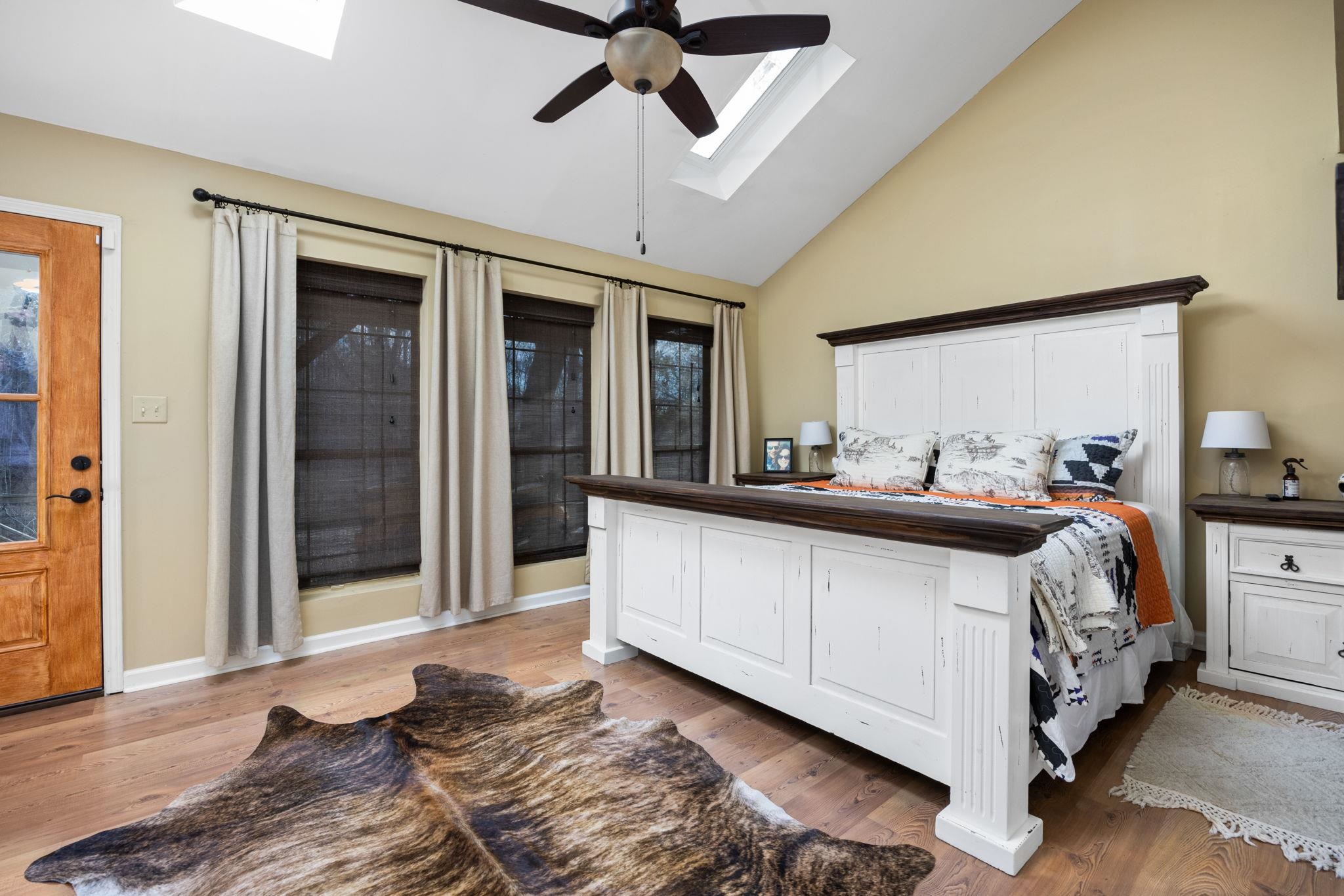 113 Horseshoe Lake Road Saltillo, MS 38866 - Photo 14 of 39 Bedroom with access to outside, lofted ceiling with skylight, light hardwood / wood-style flooring, and ceiling fan