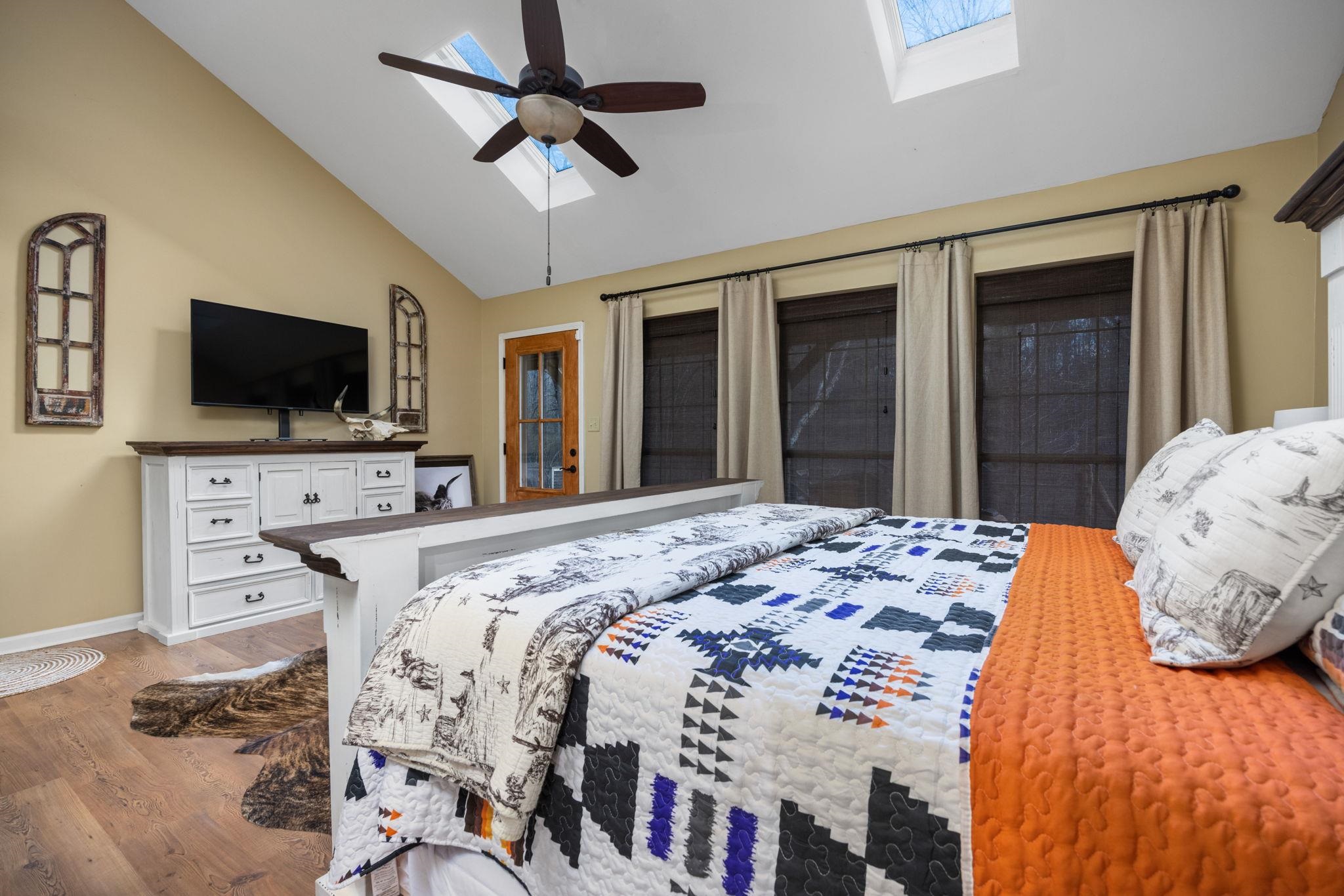 113 Horseshoe Lake Road Saltillo, MS 38866 - Photo 16 of 39 Bedroom with hardwood / wood-style flooring, ceiling fan, and lofted ceiling with skylight