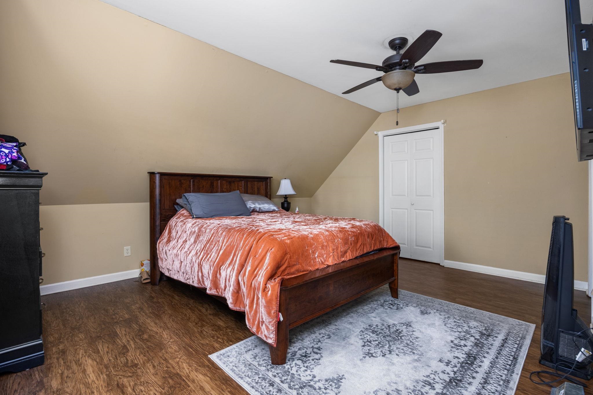 113 Horseshoe Lake Road Saltillo, MS 38866 - Photo 21 of 39 Bedroom featuring ceiling fan, a closet, dark wood-type flooring, and vaulted ceiling