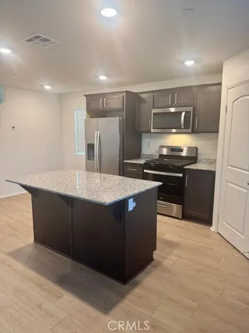 a kitchen with stainless steel appliances granite countertop a stove a refrigerator and a sink