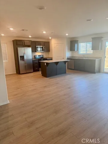 a large room with kitchen island sink and refrigerator