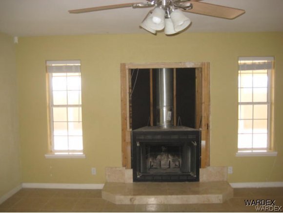 3437 Bacobi Road Golden Valley, AZ 86413 - Photo 8 of 17 an empty room with wooden floor fan and window
