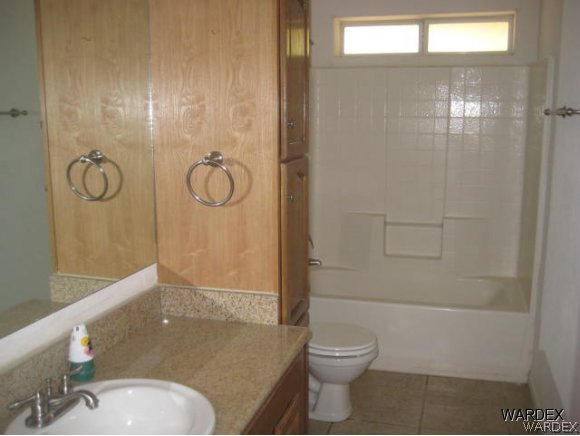 3437 Bacobi Road Golden Valley, AZ 86413 - Photo 9 of 17 a bathroom with a granite countertop sink toilet and shower