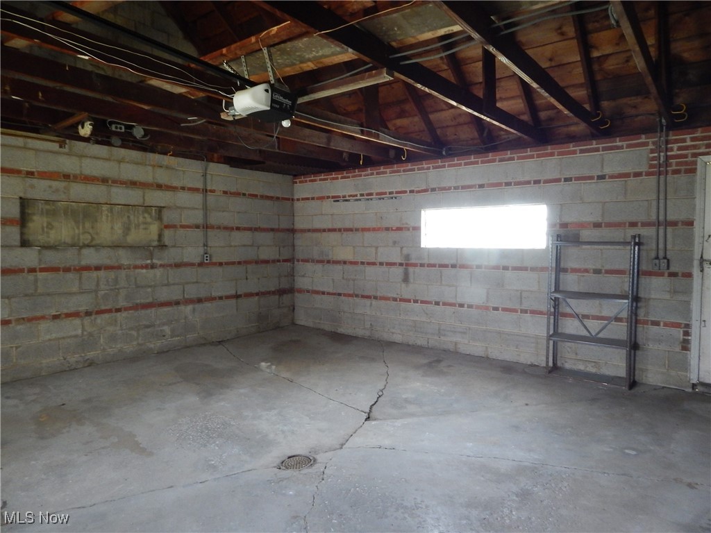 6990 Broadview Road Cleveland, OH 44134 - Photo 34 of 36 Brick and Block 2.5 car roomy Garage featuring a garage door opener.