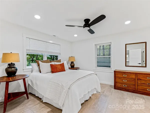 a bedroom with a bed a dresser and chair