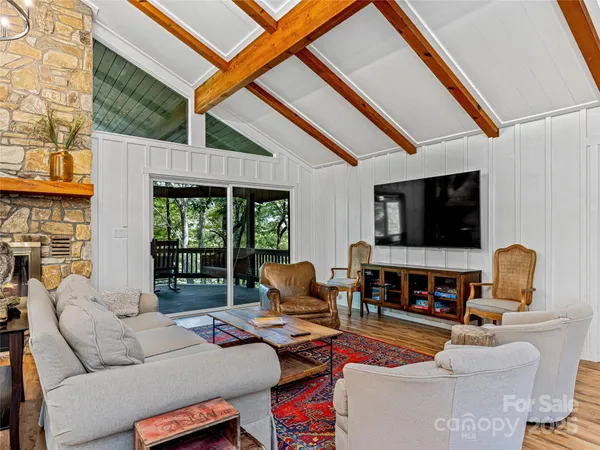a living room with furniture a flat screen tv and a floor to ceiling window