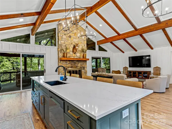 a kitchen with stainless steel appliances a sink a stove and a wooden floors