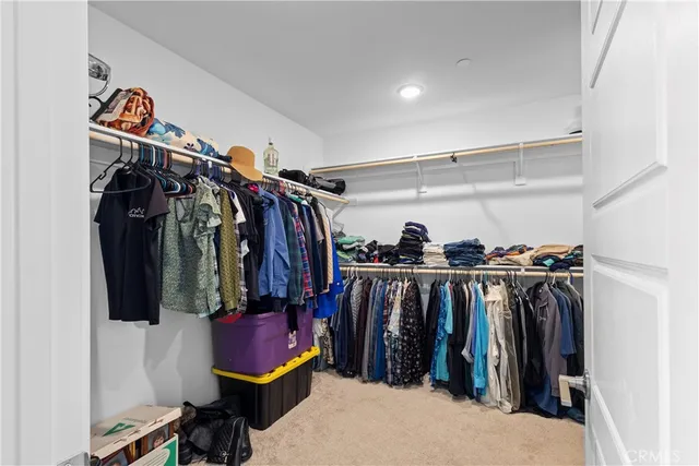 a view of walk in closet with clothes