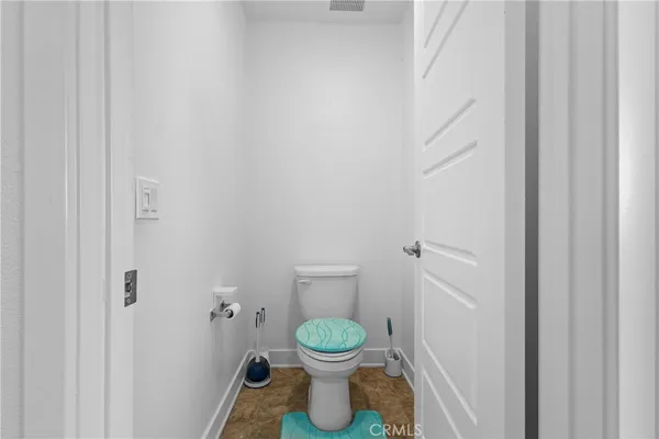 a bathroom with a granite countertop toilet and a sink