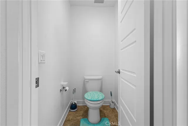 a bathroom with a granite countertop toilet and a sink