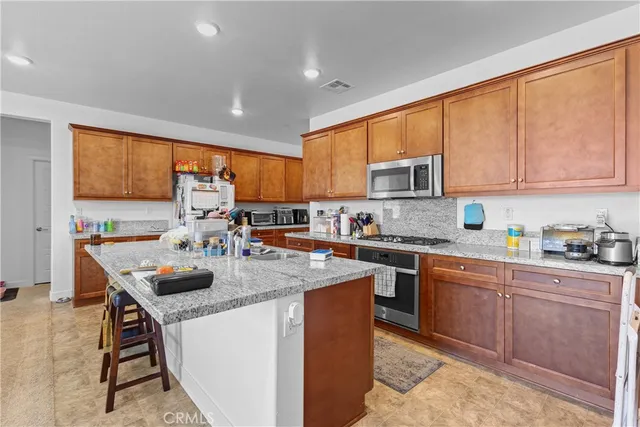 a kitchen with stainless steel appliances granite countertop sink stove top oven and cabinets