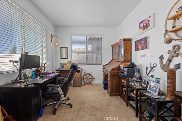 a view of a workspace with furniture and a window