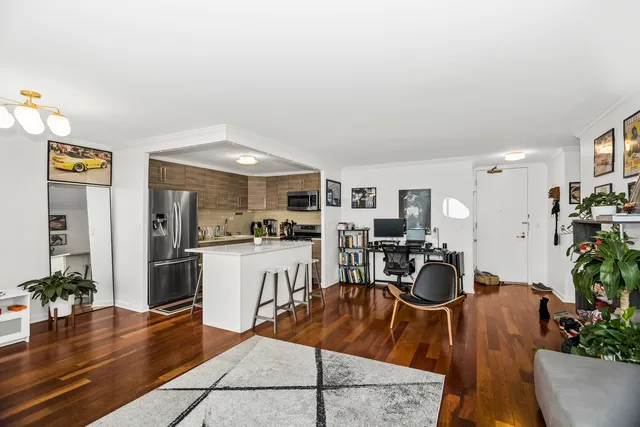 a living room with furniture a wooden floor and a kitchen