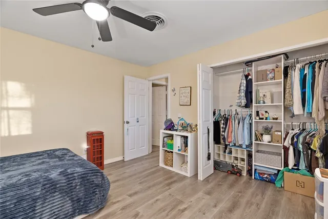 a view of walk in closet with clothes and shoes
