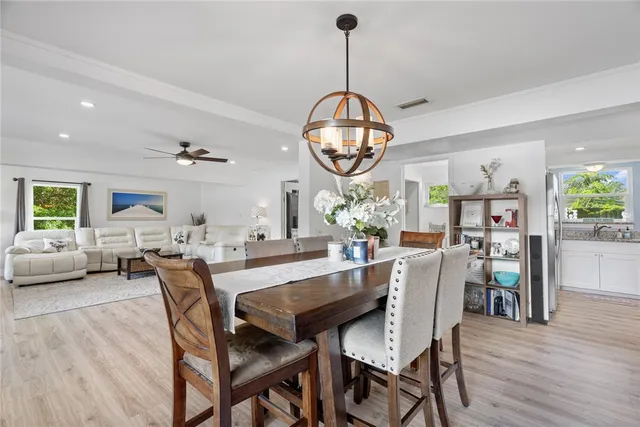 a view of a dining room with furniture a chandelier and wooden floor