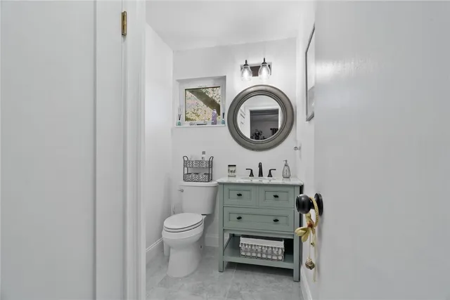 a bathroom with a toilet a sink and a mirror