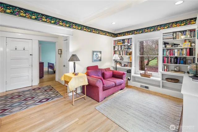 a living room with furniture and a book shelf