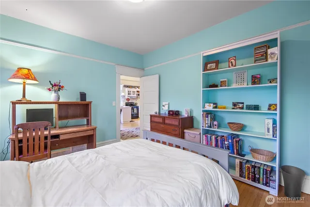 a bedroom with a bed a book shelf and a shelf