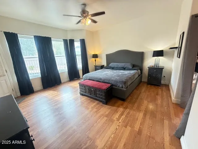 a spacious bedroom with a bed and wooden floor
