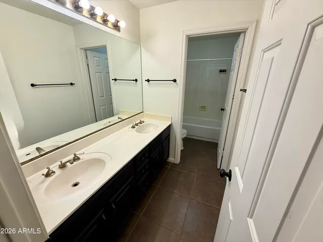 a bathroom with a double vanity sink a mirror and a shower