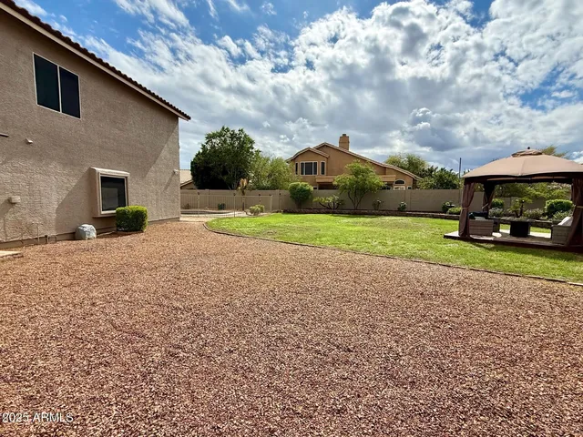 a car parked in front of a house next to a yard