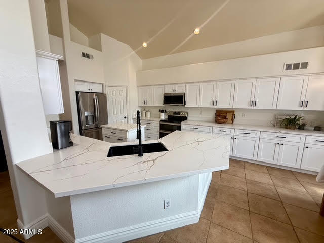 6743 East Tyndall Circle Mesa, AZ 85215 - Photo 4 of 27 a kitchen with kitchen island granite countertop a sink a stove a refrigerator cabinets and chairs