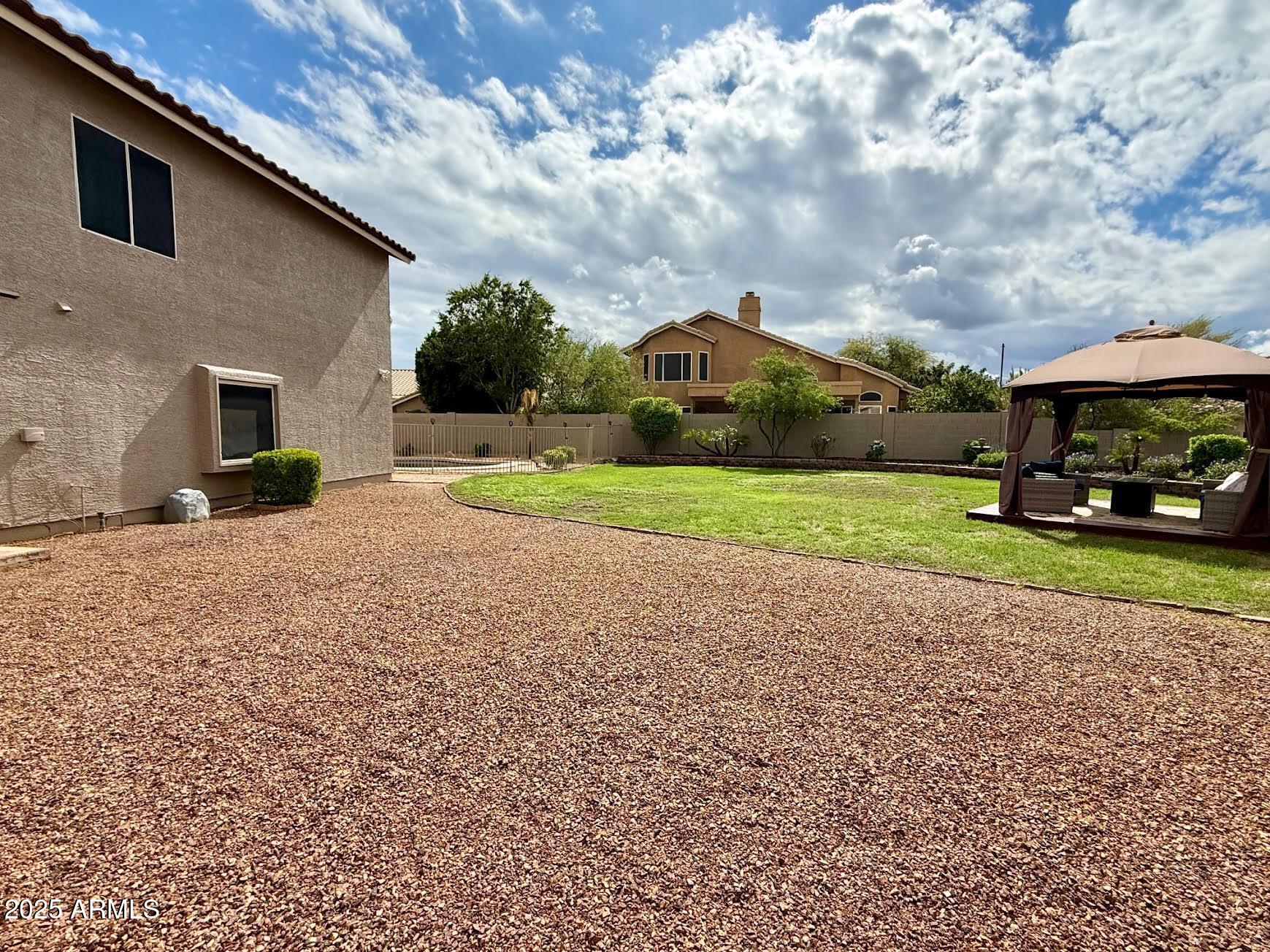 6743 East Tyndall Circle Mesa, AZ 85215 - Photo 7 of 27 a car parked in front of a house next to a yard