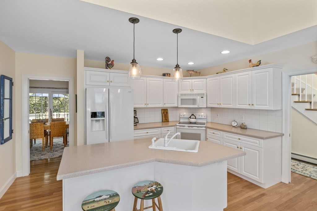 29 Spruce Road Harwich, MA 02645 - Photo 16 of 41 a kitchen with kitchen island a sink a stove and a chandelier