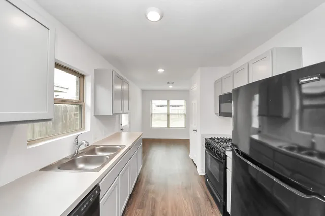 a kitchen with stainless steel appliances kitchen island granite countertop a stove and a sink