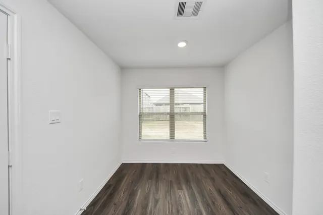 an empty room with windows and closet