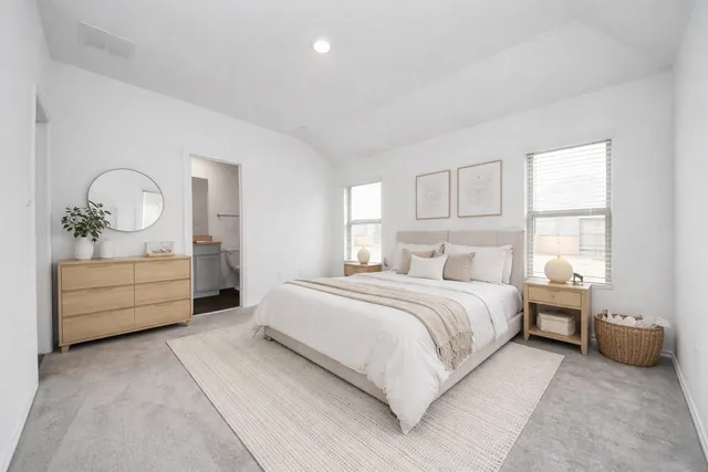 a bedroom with a bed a mirror and a window