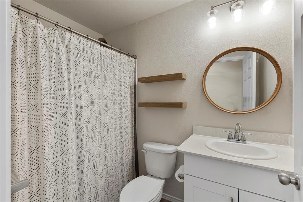 10121 Wyseby Road Crowley, TX 76036 - Photo 22 of 25 a bathroom with a toilet a sink and a mirror