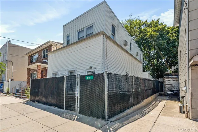 a view of a house with a backyard and wooden fence
