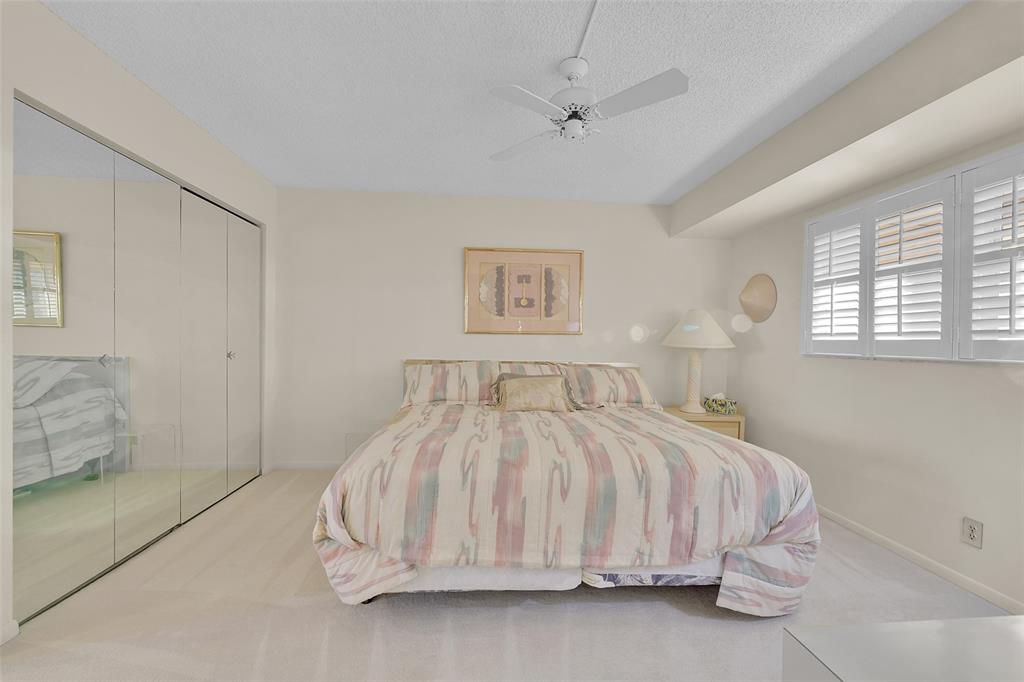 5340 Northwest 2nd Avenue, Unit PH26 Boca Raton, FL 33487 - Photo 19 of 53 a bedroom with a bed and a painting on the wall