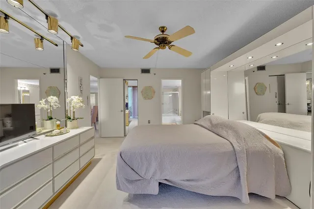 a spacious bedroom with a bed and a chandelier