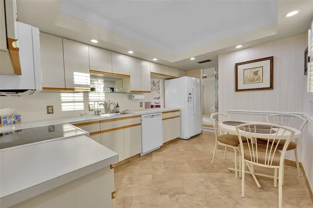a kitchen with a sink a counter top space stainless steel appliances and cabinets