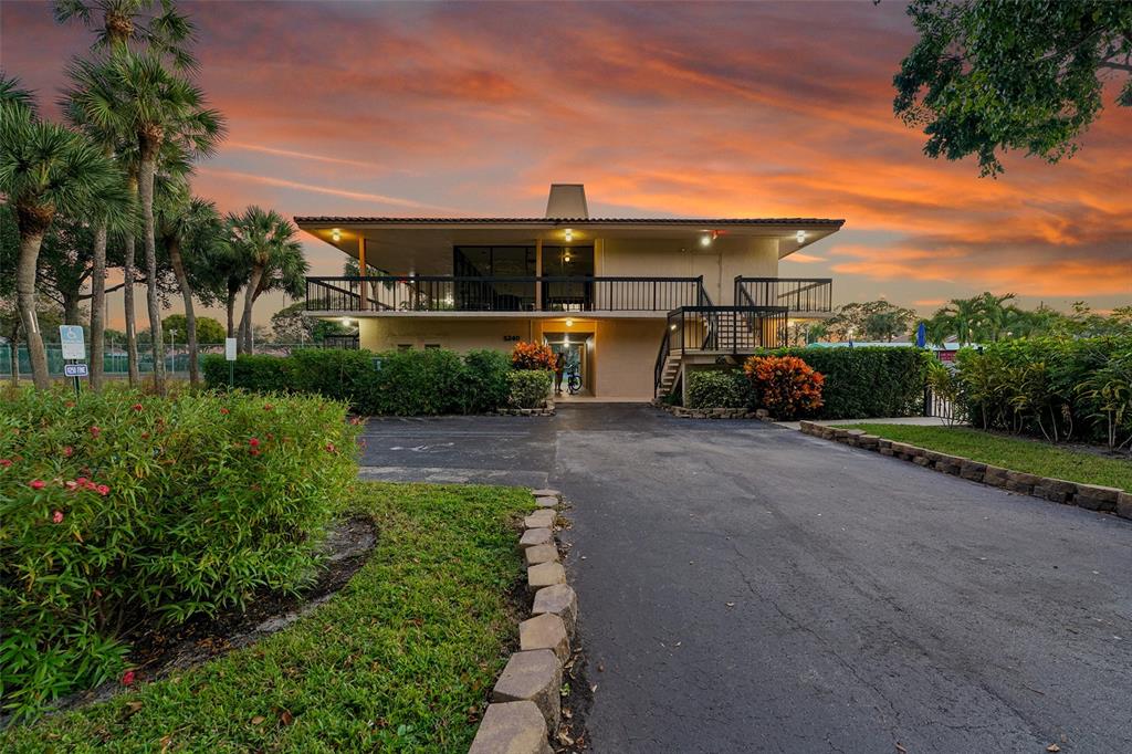 5340 Northwest 2nd Avenue, Unit PH26 Boca Raton, FL 33487 - Photo 40 of 53 a front view of a house with a yard and potted plants