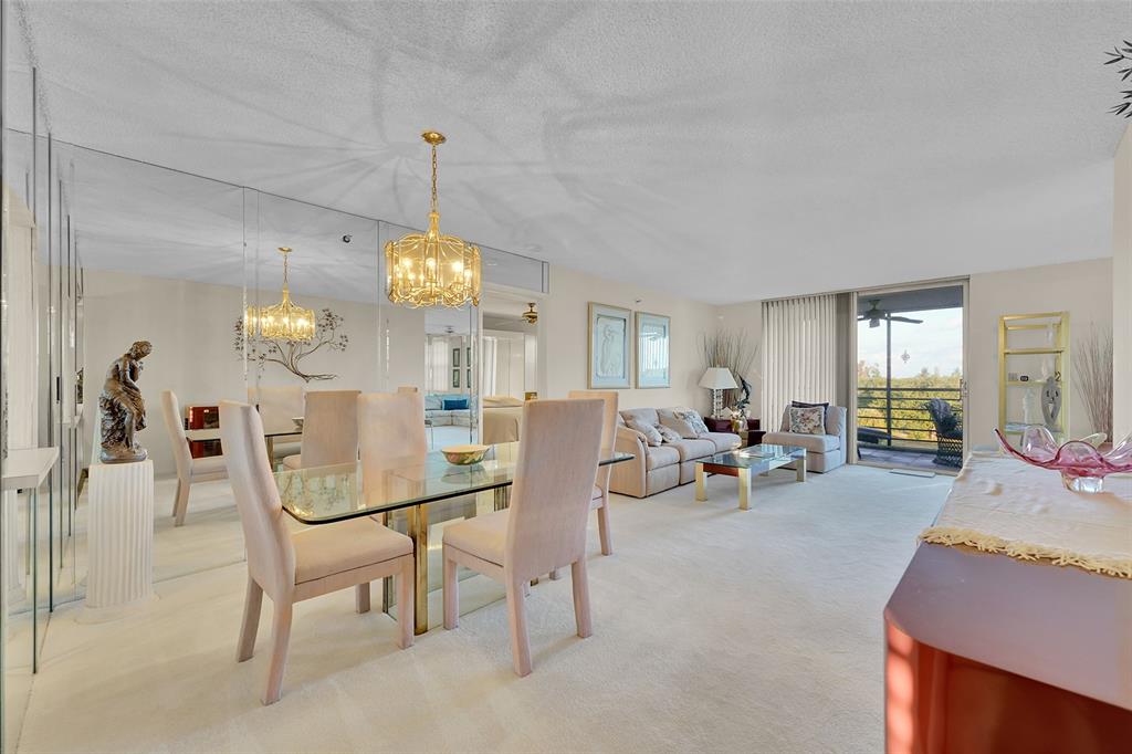 5340 Northwest 2nd Avenue, Unit PH26 Boca Raton, FL 33487 - Photo 8 of 53 a living room with furniture a chandelier and a dining table