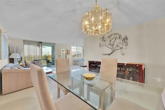 a view of a dining room with furniture a chandelier and wooden floor