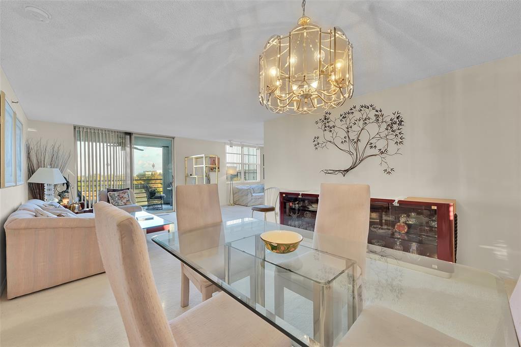 5340 Northwest 2nd Avenue, Unit PH26 Boca Raton, FL 33487 - Photo 9 of 53 a view of a dining room with furniture a chandelier and wooden floor