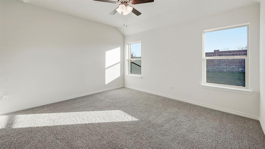 419 Epiphany Lane Lavon, TX 75166 - Photo 16 of 31 Spacious room featuring vaulted ceilings, light gray carpeting, two large windows, and a ceiling fan