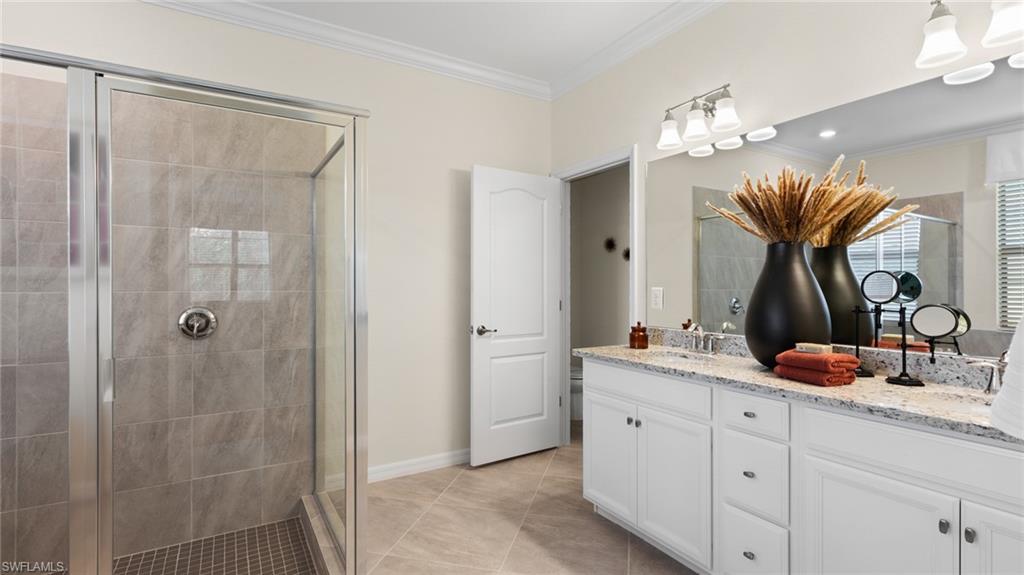 20641 Copperhead Drive Lehigh Acres, FL 33936 - Photo 15 of 27 a bathroom with double vanity and a mirror