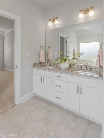 a spacious bathroom with a granite countertop sink and a mirror
