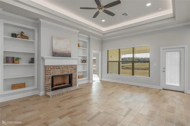 a view of an empty room with a fireplace and a window