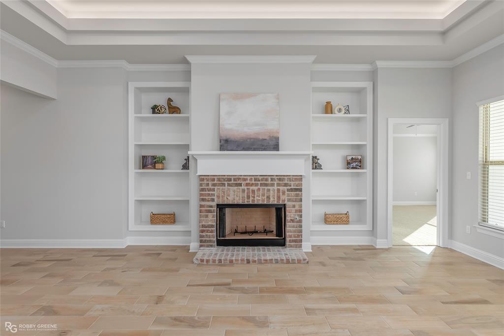 727 Bianca Street Haughton, LA 71037 - Photo 3 of 22 a living room with a fireplace and a book shelf