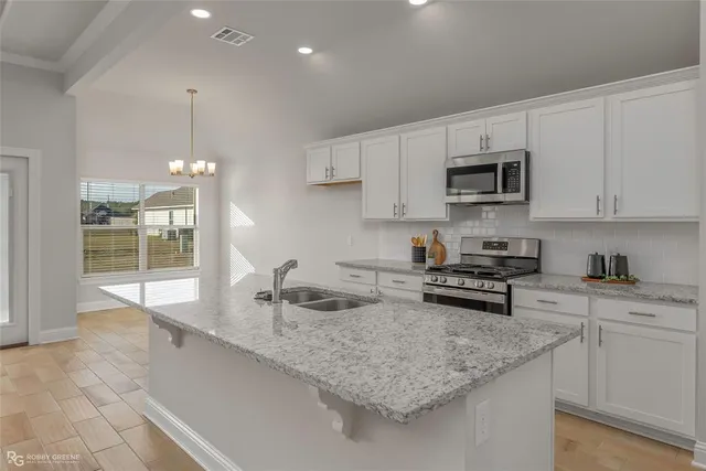 a kitchen with stainless steel appliances granite countertop a sink stove and cabinets