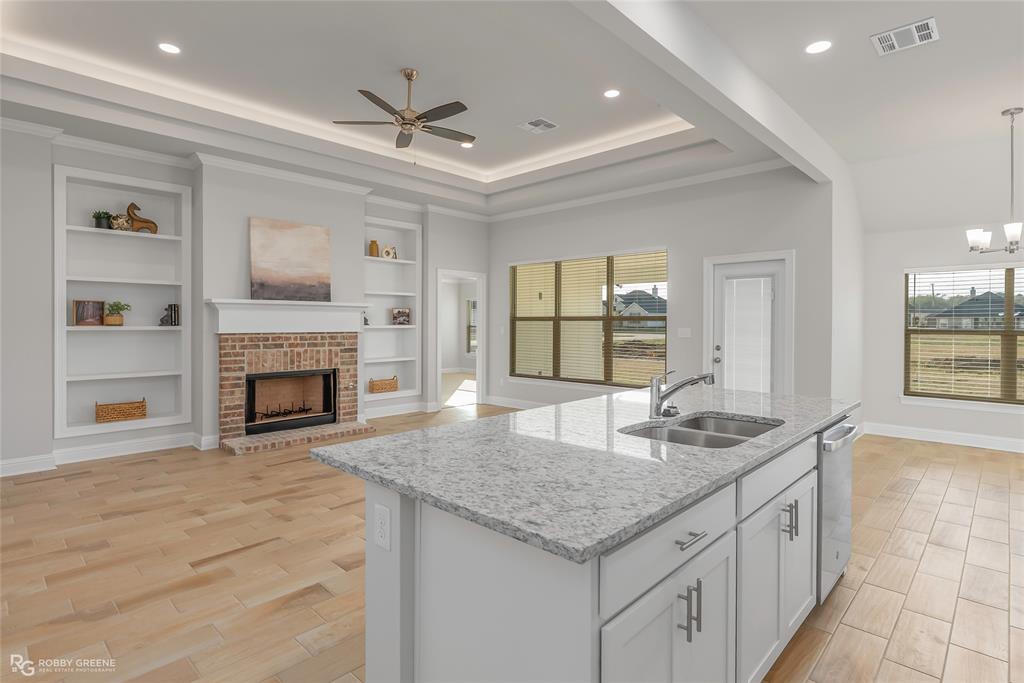 727 Bianca Street Haughton, LA 71037 - Photo 7 of 22 a kitchen with sink granite counter top and a fireplace