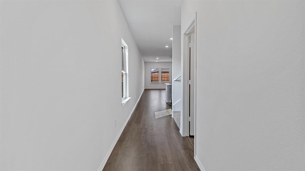 Hallway featuring wood-finish flooring, white walls, and recessed lighting