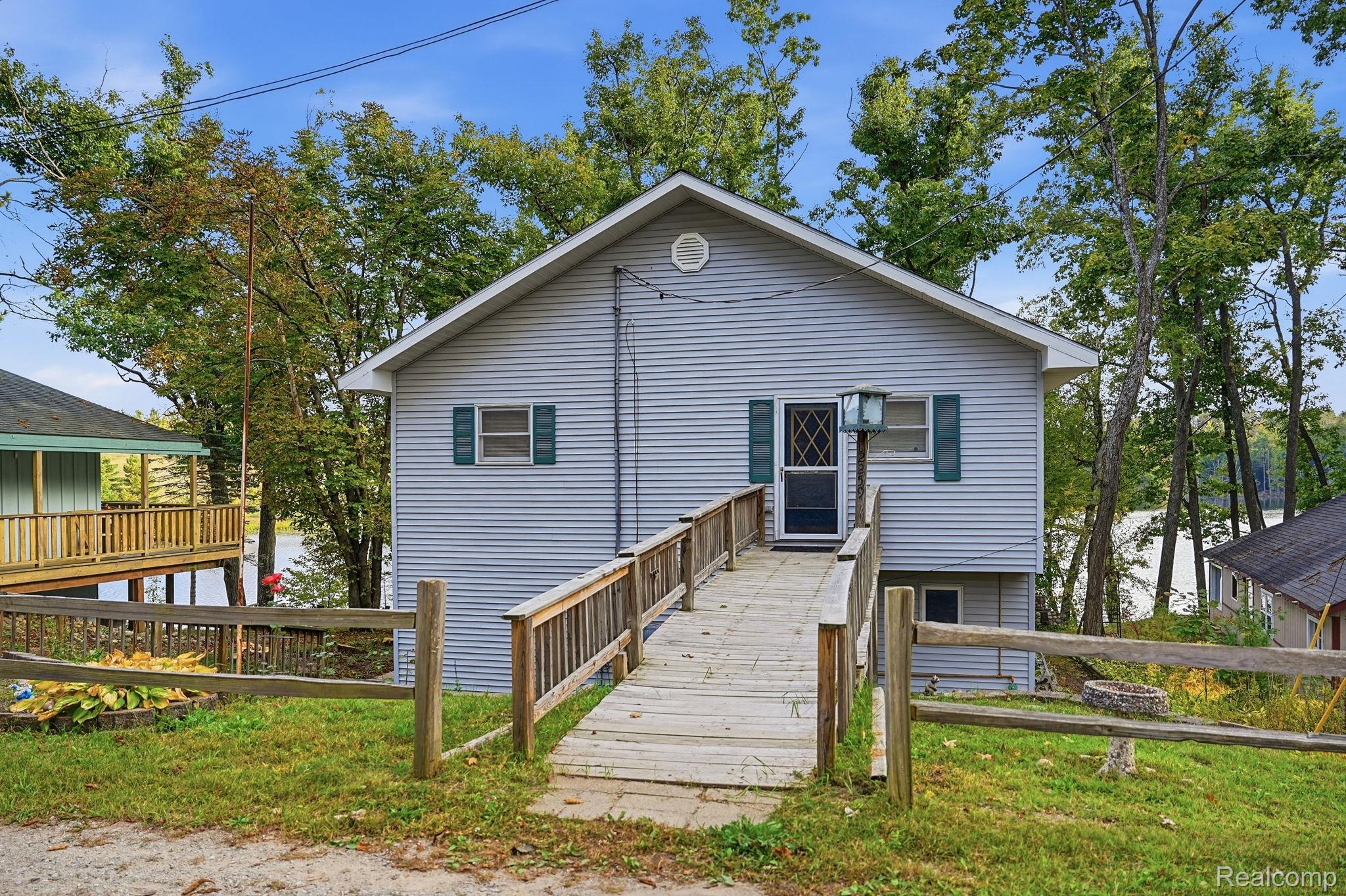 2259 Kassuba Road Gaylord, MI 49735 - Photo 32 of 46 Gabled exterior with horizontal siding, featuring a covered entry and a long wood-finish ramp